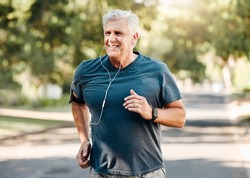 Senior man running while listening to music outdoor street and park for fitness, wellness or healthy lifestyle with summer lens flare bokeh. Elderly person exercise, workout or jogging with earphones