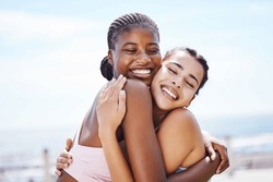 Women, hug and success after fitness, workout and training by beach, sea or ocean in Miami, Florida. Smile, happy or embrace sports friends in celebration of exercise goals, health target or wellness