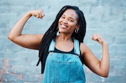 Happy black woman, portrait smile and muscle power, strength and confident pose on wall background. Proud African female flexing biceps, muscles and smiling for women empowerment in South Africa