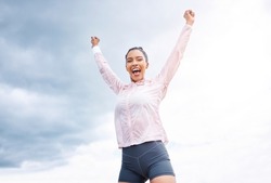 Fitness, woman and runner in victory, win or achievement for sports exercise, workout or training in cloudy sky background. Happy active female runner celebrating, winning and success in the outdoors
