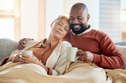 Black couple relax on sofa with coffee, blanket and smile on winter weekend morning in home. Peace, comfort and love, happy man and tired woman, cozy time on couch with drink in living room together.