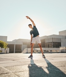 Fitness, man and stretching arm in the city for warm up exercise, training or cardio workout in the outdoors. Active male in morning stretch for sports activity, performance or exercising in the town