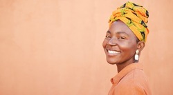 African, culture and portrait of happy black woman with pride in unique tradition, origin and South Africa heritage. Fashion mock up, head wrap and face of beauty girl isolated on mockup orange wall