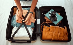 Travel suitcase, bedroom and hands of woman packing for Europe holiday, vacation or adventure tourist journey. Hospitality, hotel bed and photographer with luggage bag, clothes and camera in Madrid