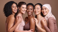 Skincare, diversity and women hug portrait for inclusivity, happiness and healthy skin texture. Interracial beauty and model group with woman in hijab smile for cosmetic campaign in brown studio