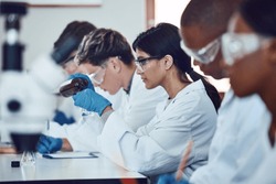 Diversity, scientist and people in science exam, test or group project in experiment or assignment at laboratory. PHD students in scientific research, chemical or forensics with safety uniform in lab