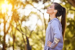 Calm, music and fitness person in nature for mental health, wellness and breathing, forest trees and fresh air. Mockup, sports and athlete woman thinking or listening to audio for running inspiration