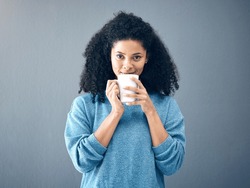 Coffee, tea and portrait of black woman drinking an espresso in a cup isolated in a studio gray background. Morning, relax and female with hot beverage with caffeine for energy and feeling happy