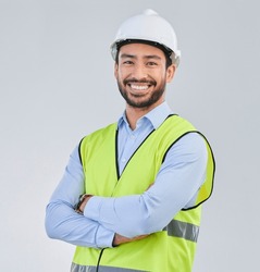 Construction worker, engineer and studio portrait of happy man in vest and helmet for safety on white background. Smile, contractor or architect in planning or renovation, project manager in India.