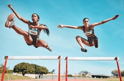 Sports, hurdles and team of women on track running in a race, marathon or competition in stadium. Fitness, workout and female athletes jumping with speed and energy for outdoor training or practice.