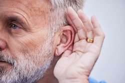 Senior man, listening and hand on ear or curious guy with gesture to hear gossip, conversation or announcement. Hearing, loss and old person with a disability or deaf male with hands to listen