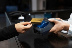 Customer using credit card for payment to receptionist. cashless technology and credit card payment concept. customer paying with contactless credit card. NFC technology. credit card reader machine.