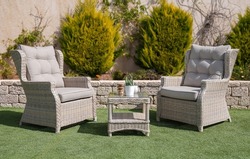 Rattan chairs and a table outdoors.
