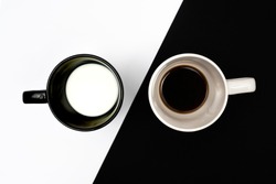 the contrast of a cup of coffee and a cup of milk