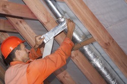 installer wraps the air duct with mineral wool and foil