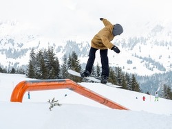 Snowboarder jumping on a rail