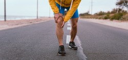 Runner man with knee injury and pain on the road