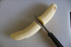 A banana that has been cut in half, ready to be used in a smoothie