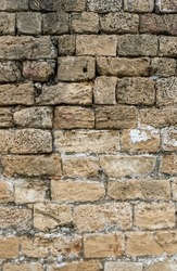 Old Brick Wall. Stone Fence. Wheathered Brickwall with White pieces of Plaster. vertical Stock Photo
