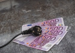 Black electric cable and 500 euro banknotes. expensive electricity