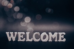 WELCOME word made with white letters on dark background.