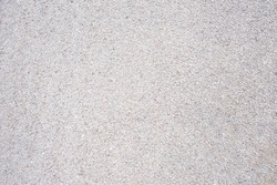 Granular soil texture with gravel particles, small stones, black, gray and white grains. Close-up, top view. Gray asphalt pattern. Bitumen road texture
