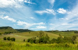 Australian countryside landscape, with wide-ranging field and rolling hills. Image taken from a fast moving vehicle.