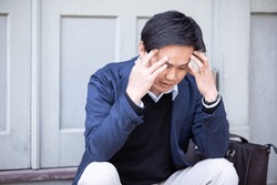 casual business asian man holding his head