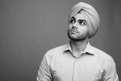 Young handsome Indian Sikh businessman wearing turban
