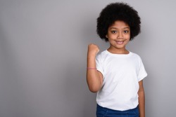 Studio shot of young cute African girl against gray background