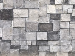 Modern outdoor building stonewall background texture decorated with multicolored split face natural ledge stone tile with regular and rectangular mosaic pattern. Close up
