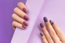 Beautiful purple burgundy matte manicure on creative background. Fashionable spring summer nail design.