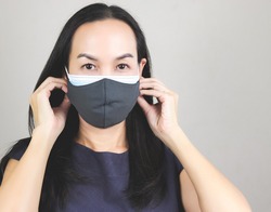 Close up image of Asian woman wearing  double face masks  or two face masks for better protection  from coronavirus or covid-19 outbreak - concept of safety, healthcare, medical and hygiene.