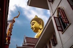 Huge Buddha image that appears between the buildings. big buddha Buddha image on the roof of buildings. Buddha temple in Thailand