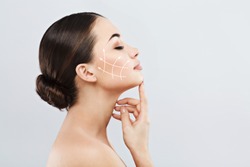 Profile of young female with clean fresh skin, antiaging concept. Girl touching face with closed eyes, lifting arrows showing facial anti-aging treatment on skin