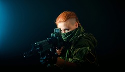Woman with red hair, hold machinegun and takes aim at the sight. horizontal background
