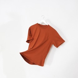 Orange tshirt with hanger. Flying cotton T-shirt isolated on white background.