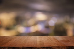  Empty brown wooden table and blur background of abstract  of resturant lights people enjoy eating ,can be used for montage or display your products
 