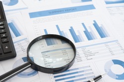 Data Analysis. Magnifying glass with business report on financial advisor desk. Concept of business research, accounting,audit, business analysis,financial planning,