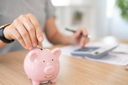 savings and finance concept. woman putting money coin in piggy bank for saving money and plan finance.