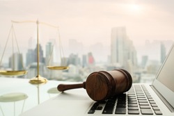 law legal technology concept.  judge gavel on computer with scales of justice on desk of lawyer.