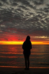 A Young Adolescent Girl Looks up in Awe, Wonder, and Admiration at a Magnificent Sunset Sky