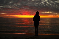 A Young Adolescent Girl Looks up in Awe, Wonder, and Admiration at a Magnificent Sunset Sky