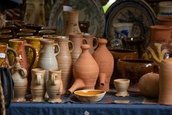 Ceramic clay terracotta jug, pot, vase, kitchen souvenirs on shelf at street handicraft pottery shop. Old earthen terracotta jug, pot, clay jar pattern in store. Clay brown various ceramic pot  jugs