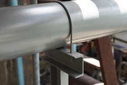 Water pipes are placed on steel support and fastened with u-bolts.