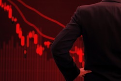 World economy and business in crisis concept. Red tone businessman watching stock market collapse.