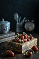 fresh strawberry in wooden basket with darkmood editing.