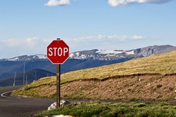 Stop sign on mountain with blue sky background 
