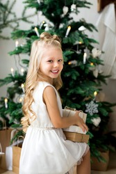 Happy little smiling girl with christmas gift box. Merry Christmas and Happy Holidays.