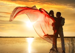 Silhouette of couple in love on sunset background